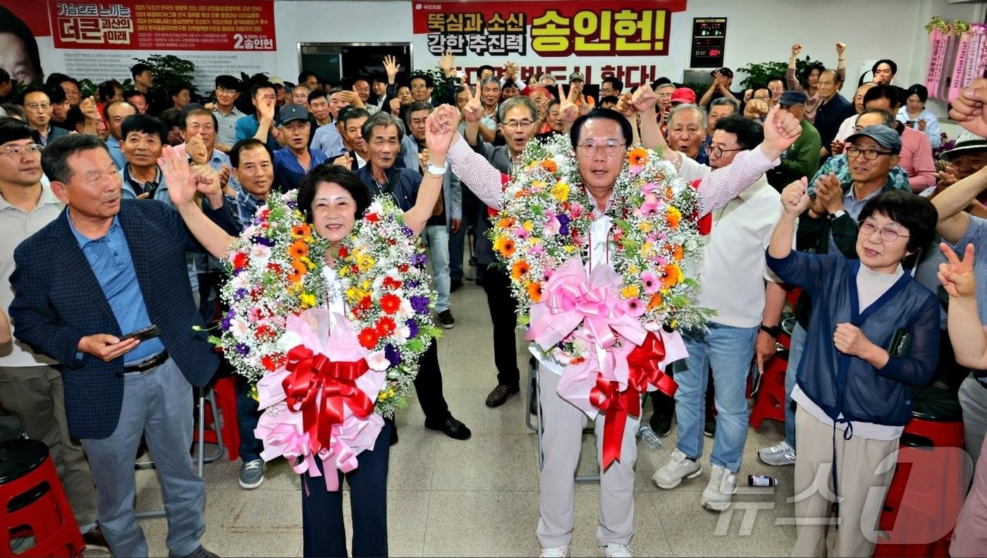 본문 이미지 - 송인헌 국민의힘 괴산군수 후보가 3일 충북 괴산 선거사무실에서 당선이 확정된 후 지지자들로부터 꽃다발을 받은 뒤 팔을 들어 환호하고 있다.(송인헌선거사무소 제공. 재판매 및 DB금지)2026.6.3/뉴스1 이성기 기자