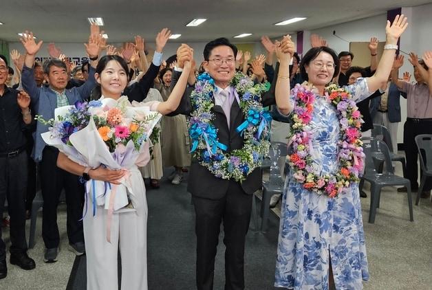 본문 이미지 - 윤건영 충북교육감 후보가 3일 충북 선거사무소에서 당선이 확실시되자 아내와 딸의 손을 잡고 기뻐하고 있다. (선거캠프 제공. 재판매 및 DB금지) 2026.6.3 ⓒ 뉴스1
