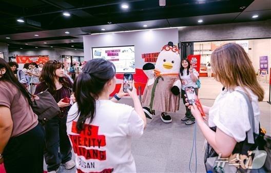 본문 이미지 - 부산유라시아플랫폼 월컴센터에서 관광객들이 부산시 대표 공식 소통 캐릭터 '부기'와 사진을 찍고 있다.(부산시 제공. 재판매 및 DB금지)