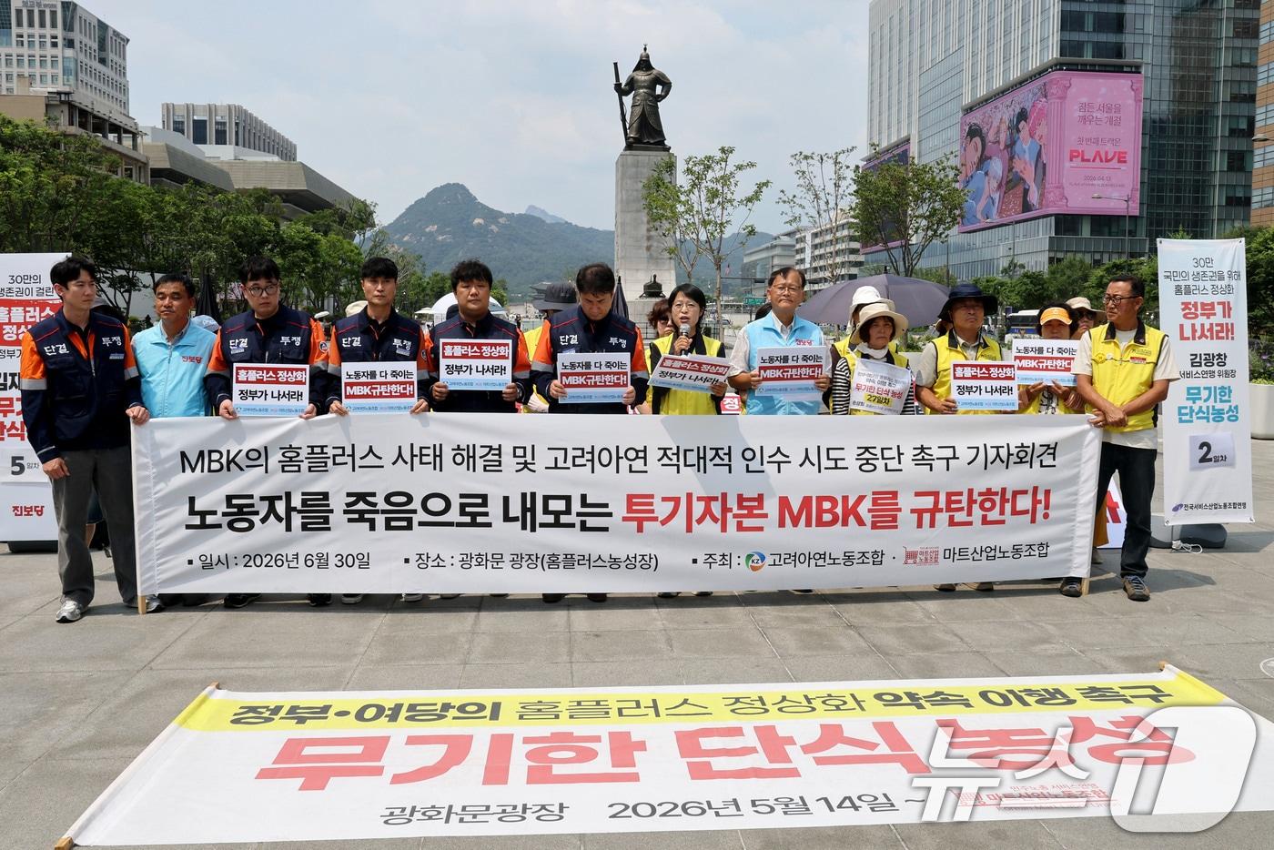 본문 이미지 - 한국노총 고려아연노동조합과 민주노총 마트산업노동조합 관계자들이 30일 오후 서울 종로구 광화문광장에서 열린 MBK의 홈플러스 사태 해결 및 고려아연 적대적 인수 시도 중단 촉구 기자회견에서 MBK를 규탄하는 피켓을 들고 있다. 2026.6.30 ⓒ 뉴스1 이광호 기자