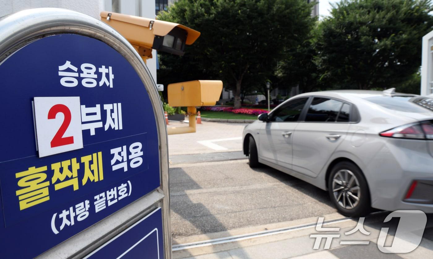 본문 이미지 - 정부는 30일 국무회의에서 원유 자원안보 위기경보를 '경계'에서 '주의'로 낮추고 액화천연가스(LNG)는 해제하기로 하면서 공공 부문 차량 2부제는 5부제로 바꾸고 공영주차장 5부제는 해제하기로 했다. 사진은 이날 서울 종로구 세종대로 정부서울청사 정문 차량 2부제 안내 모습. 2026.6.30 ⓒ 뉴스1 김명섭 기자