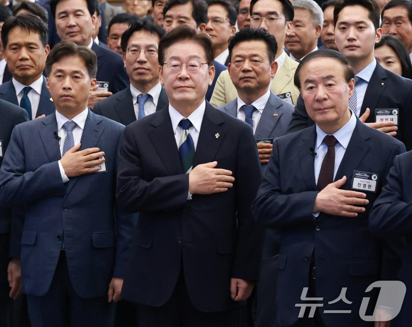 본문 이미지 - 이재명 대통령이 30일 광주 김대중 컨벤션센터에서 열린 서남권 첨단산업 발전비전 국민보고회에서 국민의례를 하고 있다. 앞줄 왼쪽부터 곽노정 SK하이닉스 대표, 이재명 대통령, 전영현 삼성전자 부회장. (청와대통신사진기자단) 2026.6.30 ⓒ 뉴스1 이재명 기자