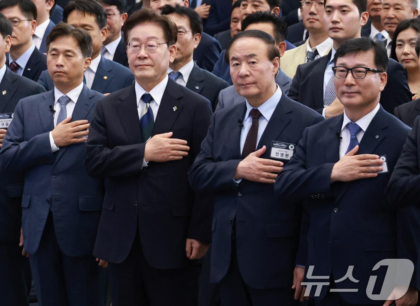 본문 이미지 - 이재명 대통령이 30일 광주 김대중 컨벤션센터에서 열린 서남권 첨단산업 발전비전 국민보고회에서 국민의례를 하고 있다. 앞줄 왼쪽부터 곽노정 SK하이닉스 대표, 이재명 대통령, 전영현 삼성전자 부회장, 이진안 앰코테크놀로지코리아 대표. (청와대통신사진기자단) 2026.6.30 ⓒ 뉴스1 이재명 기자