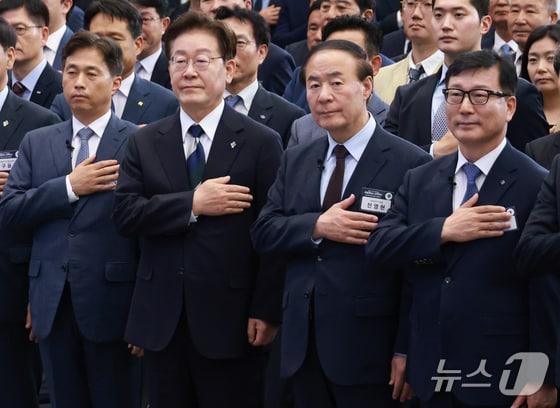 본문 이미지 - 곽노정 SK하이닉스 대표(앞줄 왼쪽부터), 이재명 대통령, 전영현 삼성전자 부회장, 이진안 앰코테크놀로지코리아 대표가 30일 광주 김대중 컨벤션센터에서 열린 서남권 첨단산업 발전 비전 국민 보고회에서 국민의례를 하고 있다.(청와대통신사진기자단) 2026. 6. 30/뉴스1 이재명 기자