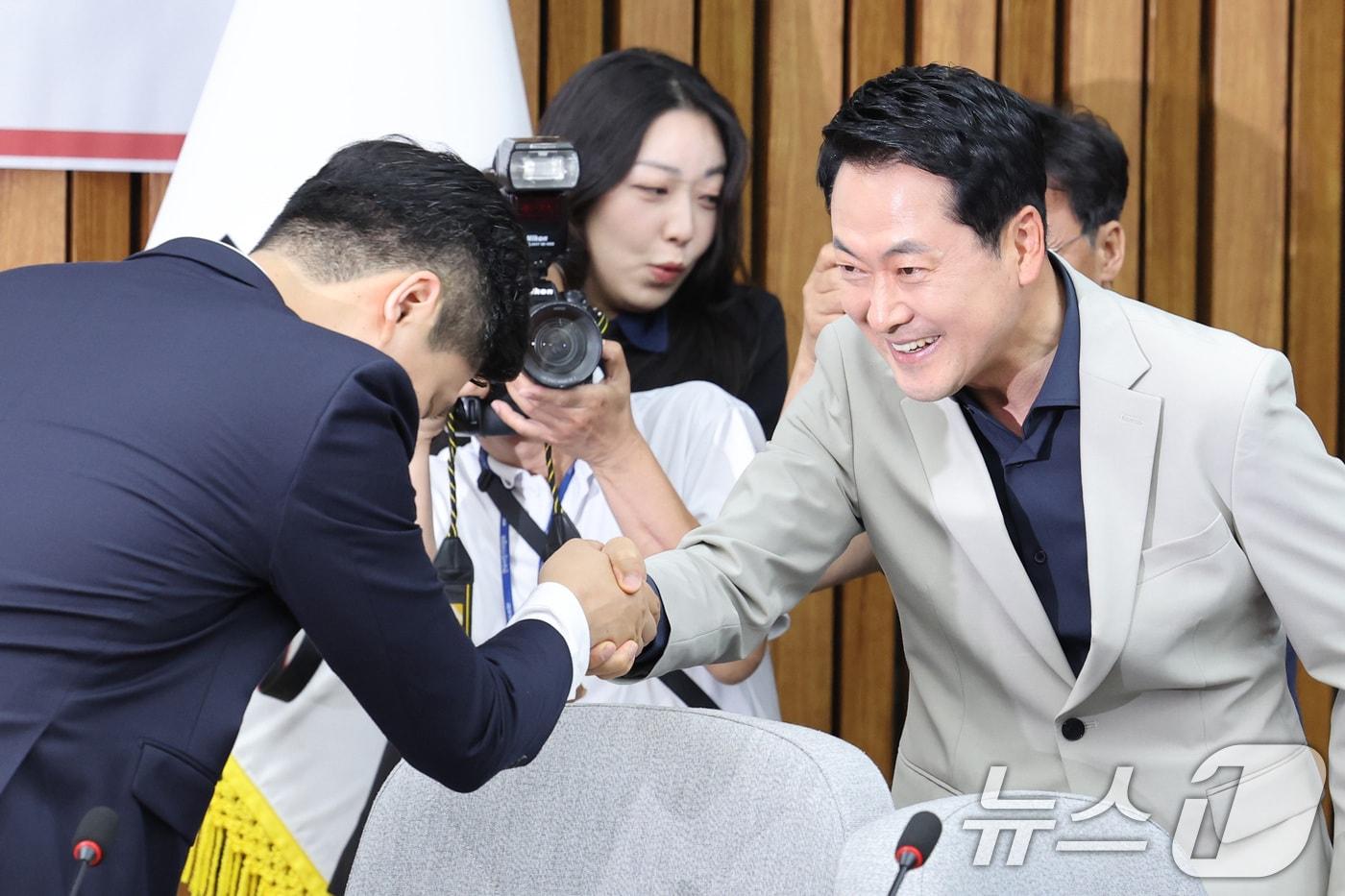 본문 이미지 - 장동혁 국민의힘 대표와 우재준 청년최고위원이 30일 서울 여의도 국회에서 열린 6.3 지방선거 참정권 박탈 사태 청년·대학생 시국 대토론회에서 악수하고 있다. 2026.6.30 ⓒ 뉴스1 신웅수 기자