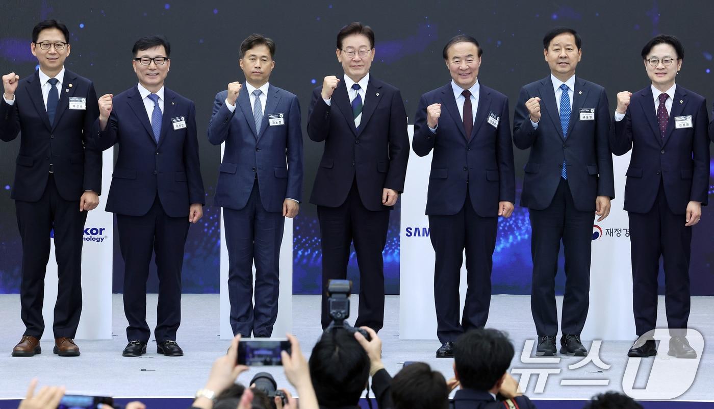 본문 이미지 - 이재명 대통령이 30일 광주 김대중 컨벤션센터에서 열린 서남권 첨단산업 발전비전 국민보고회에서 서남권 첨단산업 육성을 위한 투자양해각서를 마친 참석자들과 기념촬영을 하고 있다. 왼쪽부터 배경훈 부총리 겸 과기정통부 장관, 이진안 앰코테크놀로지코리아 대표, 곽노정 SK하이닉스 대표, 이재명 대통령, 전영현 삼성전자 부회장, 구윤철 부총리 겸 재정경제부 장관, 김정관 산업통상부 장관. (청와대통신사진기자단) 2026.6.30 ⓒ 뉴스1 허경 기자