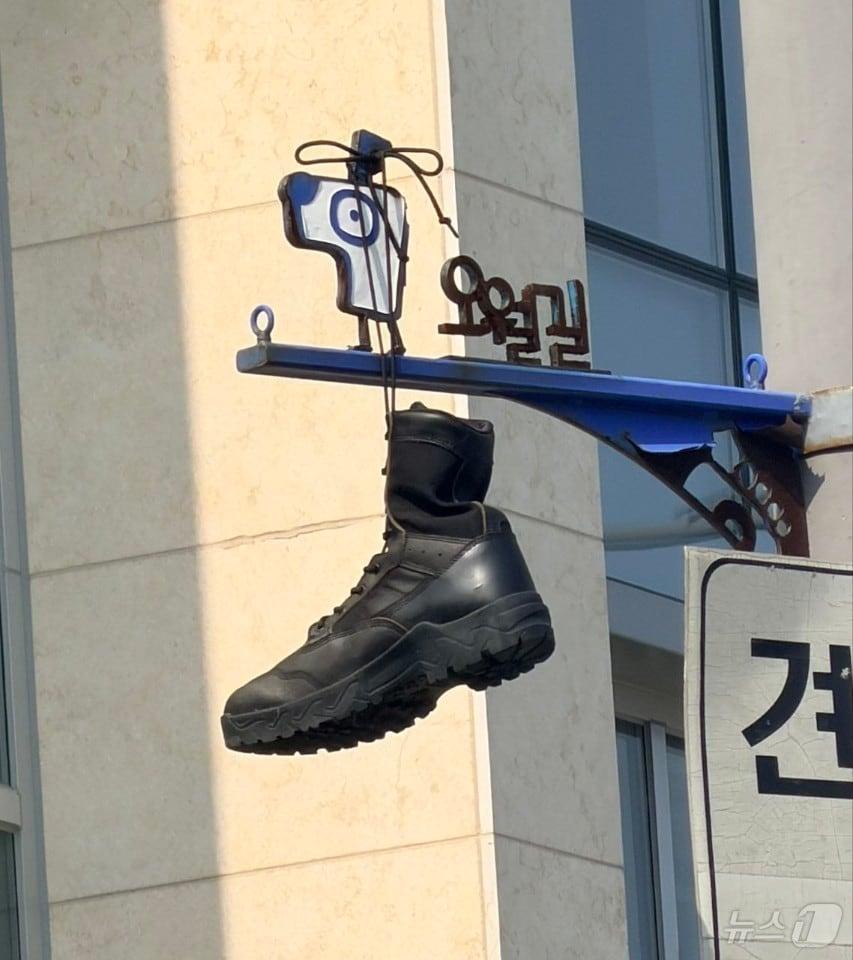 본문 이미지 - 30일 광주 동구 대인동의 한 교차로에 설치된 오월길을 안내하는 표지판에 군화가 걸려 있다. 5.18기념재단과 광주시는 군화를 수거하는 한편 누가, 어떤 의도로 군화를 걸었는지 조사에 착수했다. (5·18기념재단 제공. 재판매 및 DB금지) 2026.6.30 ⓒ 뉴스1 전원 기자