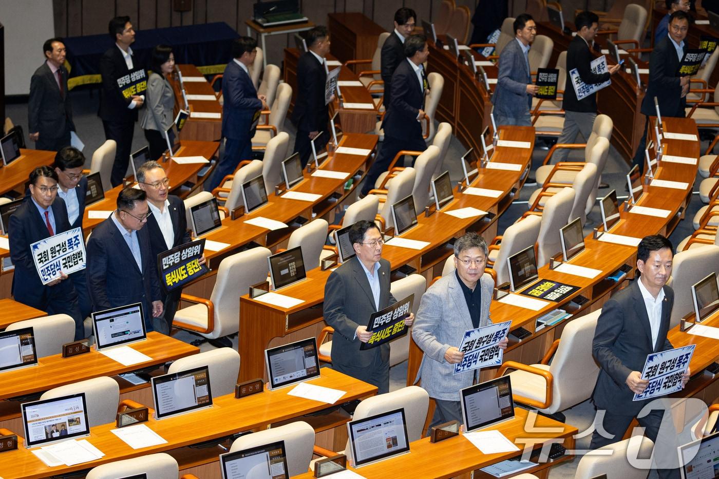 본문 이미지 - 30일 서울 여의도 국회에서 열린 제436회 국회(임시회) 제4차 본회의에서 국민의힘 의원들이 여당 단독 원구성에 반대하는 피켓 시위 중 상임위원장 선거가 시작되자 퇴장하고 있다. 2026.6.30 ⓒ 뉴스1 유승관 기자