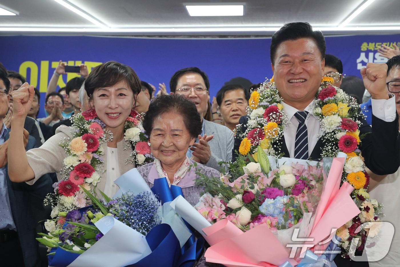 본문 이미지 - 더불어민주당 신용한 충북지사 후보와 어머니, 배우자 이채영 씨가 3일 오후 충북 청주시 흥덕구 선거사무소에서 당선이 유력시되자 꽃목걸이를 걸고 세리머니를 하고 있다. 2026.6.3 ⓒ 뉴스1 김용빈 기자