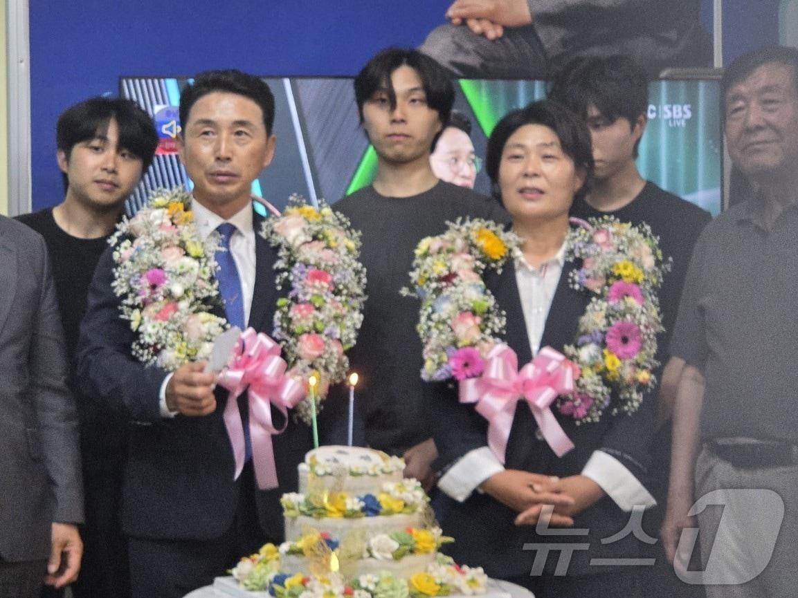 본문 이미지 - 이남오 더불어민주당 전남 함평군수 후보가 6·3지방선거에서 당선되고 배우자와 화환을 목에 걸고 있다.(이남오 캠프 제공. 재배포 및 DB 금지)