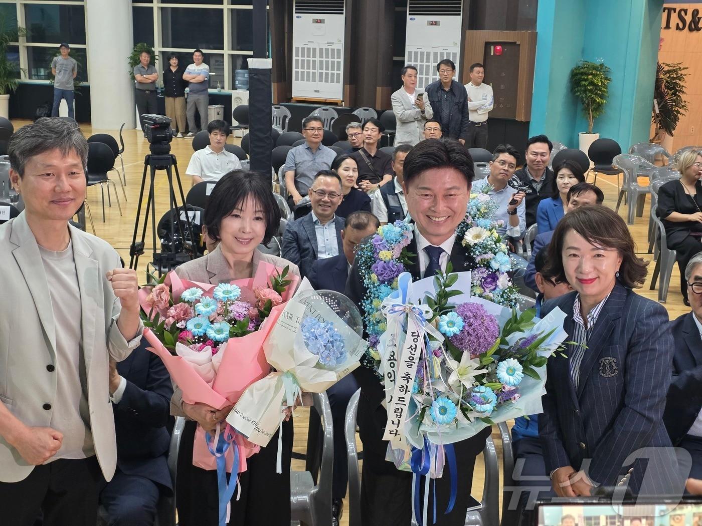 본문 이미지 - 조용익 경기 부천시장 선거 당선인이 재선 성공 기념 화환을 목에 두르고 있다/뉴스1