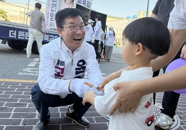 본문 이미지 - 선거운동 중 만난 아이와 반갑게 인사하는 윤건영 충북교육감 당선인.(자료사진) ⓒ 뉴스1 엄기찬 기자