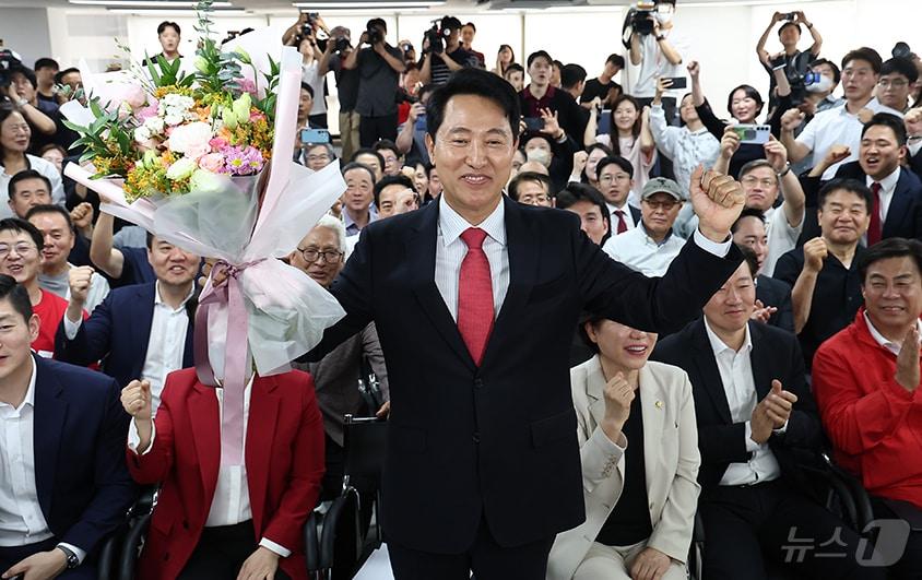 본문 이미지 - 오세훈 국민의힘 서울시장 후보가 4일 서울 종로구에 마련된 본인의 선거사무소에서 당선이 유력해지자 입장 발표 후 꽃다발을 받고 환호 있다. 2026.6.4 ⓒ 뉴스1 김도우 기자