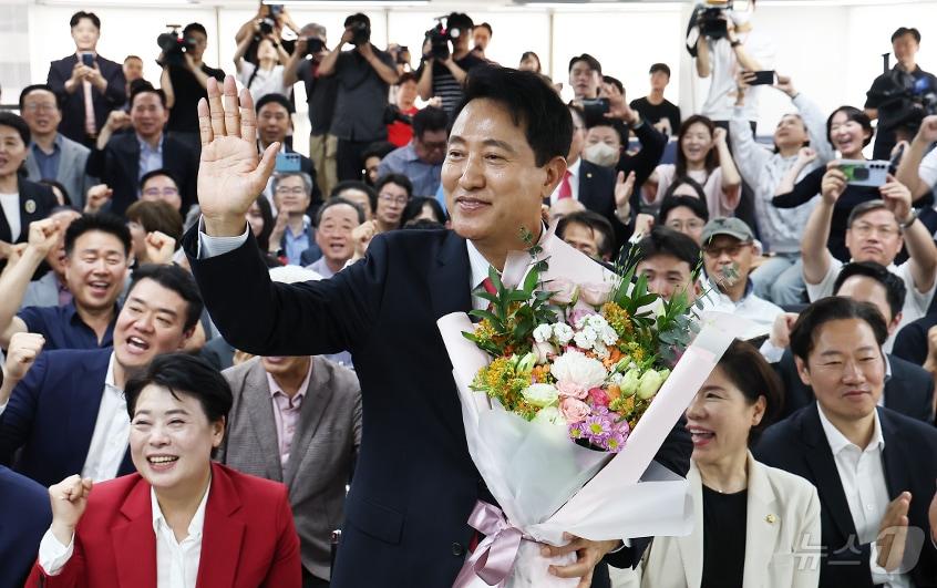 본문 이미지 - 오세훈 국민의힘 서울시장 후보가 4일 서울 종로구에 마련된 본인의 선거사무소에서 당선이 유력해지자 입장 발표 후 꽃다발을 받고 환호 있다. 2026.6.4 ⓒ 뉴스1 김도우 기자