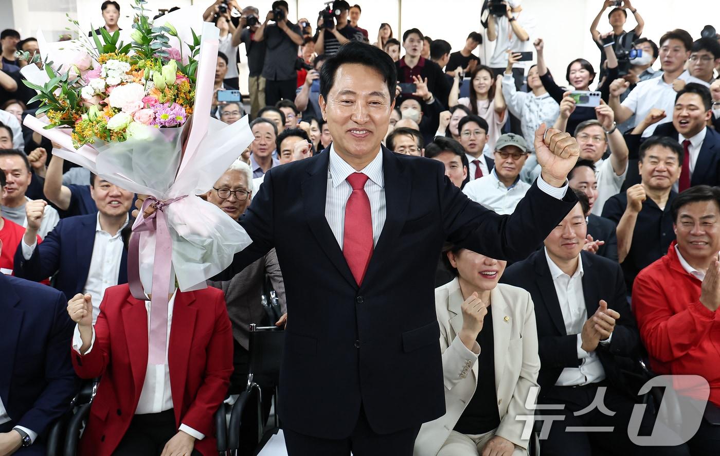 본문 이미지 - 6·3 지방선거에서 당선된 오세훈 국민의힘 서울시장 후보가 4일 서울 종로구 선거사무소에서 꽃다발을 전달 받고 환호 하고 있다. 2026.6.4 ⓒ 뉴스1 김도우 기자