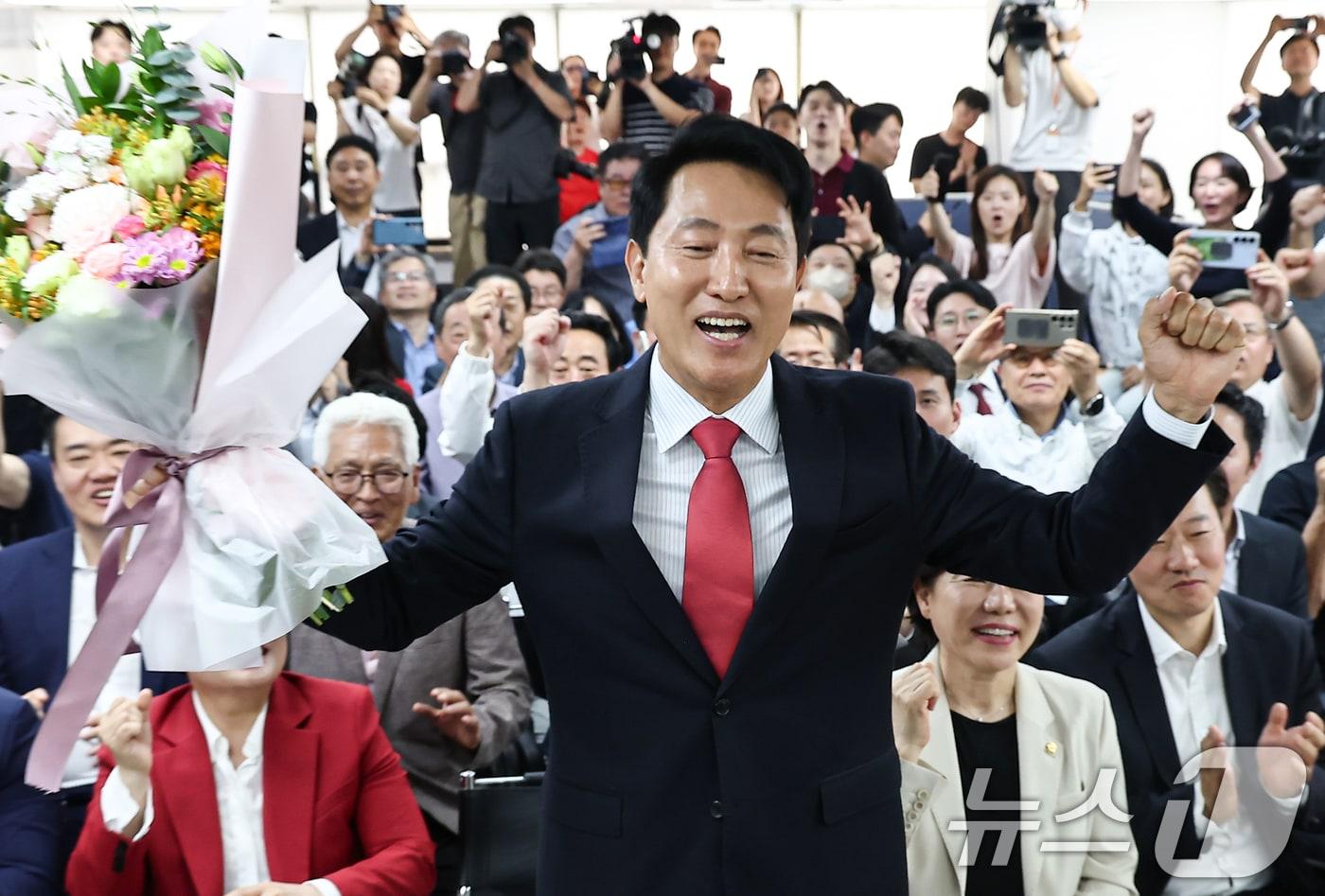 본문 이미지 - 6·3 지방선거에서 당선된 오세훈 국민의힘 서울시장이 지난달 서울 종로구 선거사무소에서 꽃다발을 전달 받고 환호하고 있다. 2026.6.4 ⓒ 뉴스1 김도우 기자