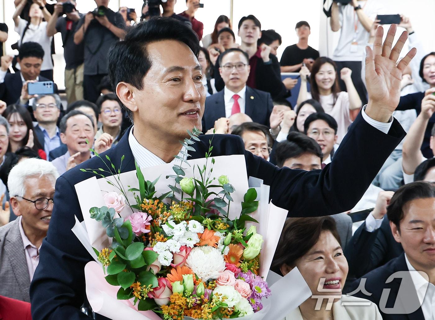 본문 이미지 - 6·3 지방선거에서 당선된 오세훈 국민의힘 서울시장 후보가 4일 서울 종로구 선거사무소에서 꽃다발을 전달 받고 환호 하고 있다. 2026.6.4 ⓒ 뉴스1 김도우 기자