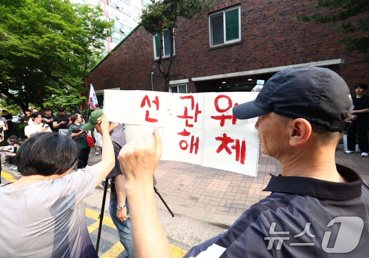 본문 이미지 - 4일 오전 제9회 전국동시지방선거 및 국회의원 재·보궐선거 투표함 이송이 지연되고 있는 서울 송파구 잠실7동 제2투표소에서 시위대와 일부 주민들이 선거관리위원회 해체를 외치고 있다. 2026.6.4 ⓒ 뉴스1 김민지 기자