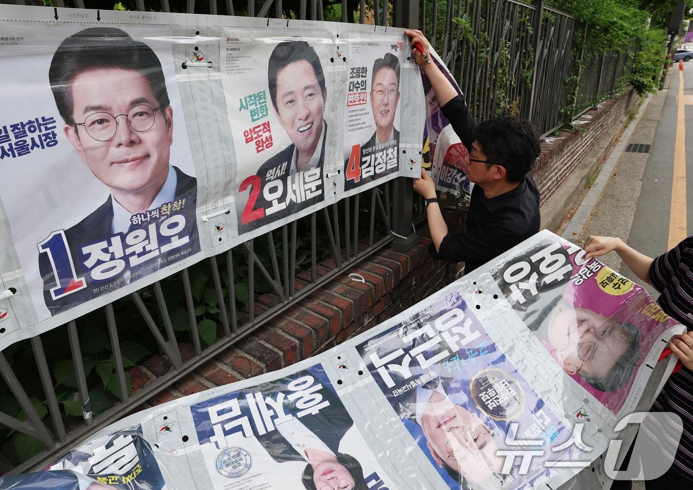 본문 이미지 - 4일 오전 서울 종로구 예술가의 집 담장에서 서울시 선거관리위원회 관계자들이 제9회 전국동시지방선거 벽보를 철거하고 있다. ⓒ 뉴스1 오대일 기자