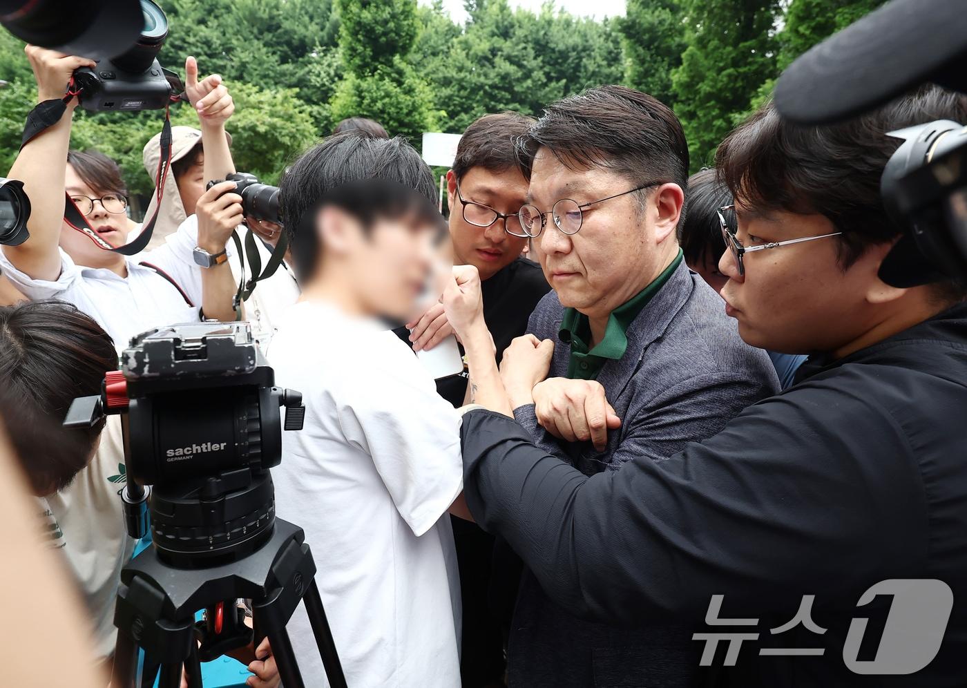 본문 이미지 - 제9회 전국동시지방선거 및 국회의원 재·보궐선거 투표함 이송이 지연된서울 송파구 잠실7동 제2투표소에서 김범진 서울시선관위 사무처장이 시위대의 반발을 받고 있다. 2026.6.4 ⓒ 뉴스1 김민지 기자