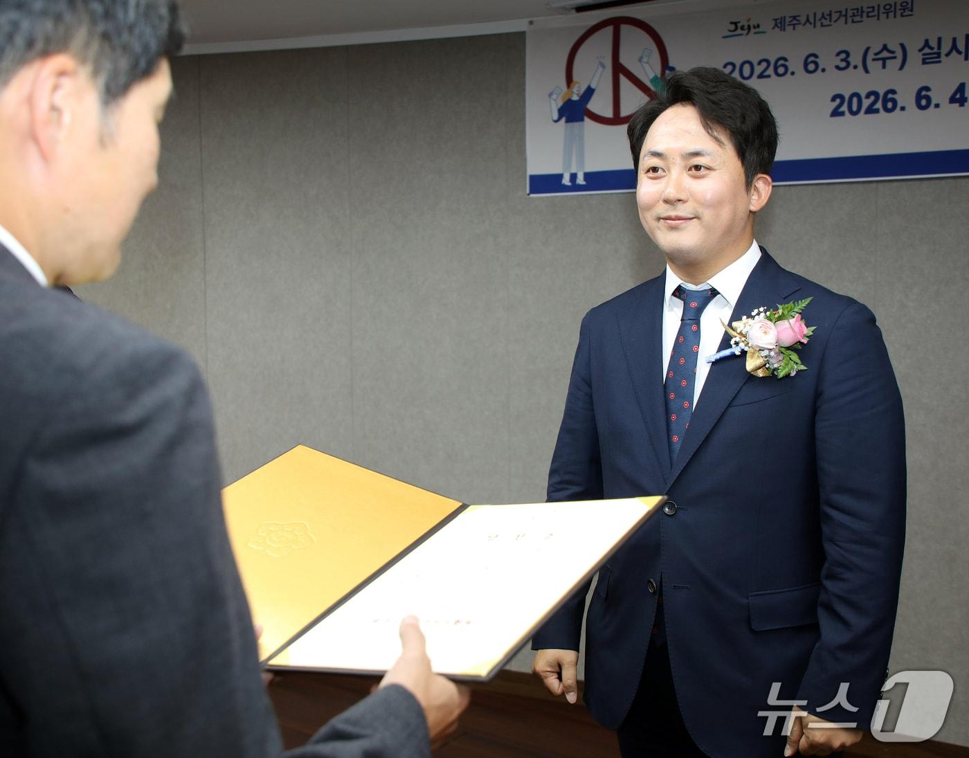 본문 이미지 - 강정범 제주도의회 의원 당선인(39·더불어민주당·제주시 오라동)이 4일 오후 제주경제통상진흥원 대회의실에서 열린 제9회 전국동시지방선거 당선증 교부식에서 당선증을 받고 있다. 2026.6.4 /뉴스1 ⓒ 뉴스1 오미란 기자