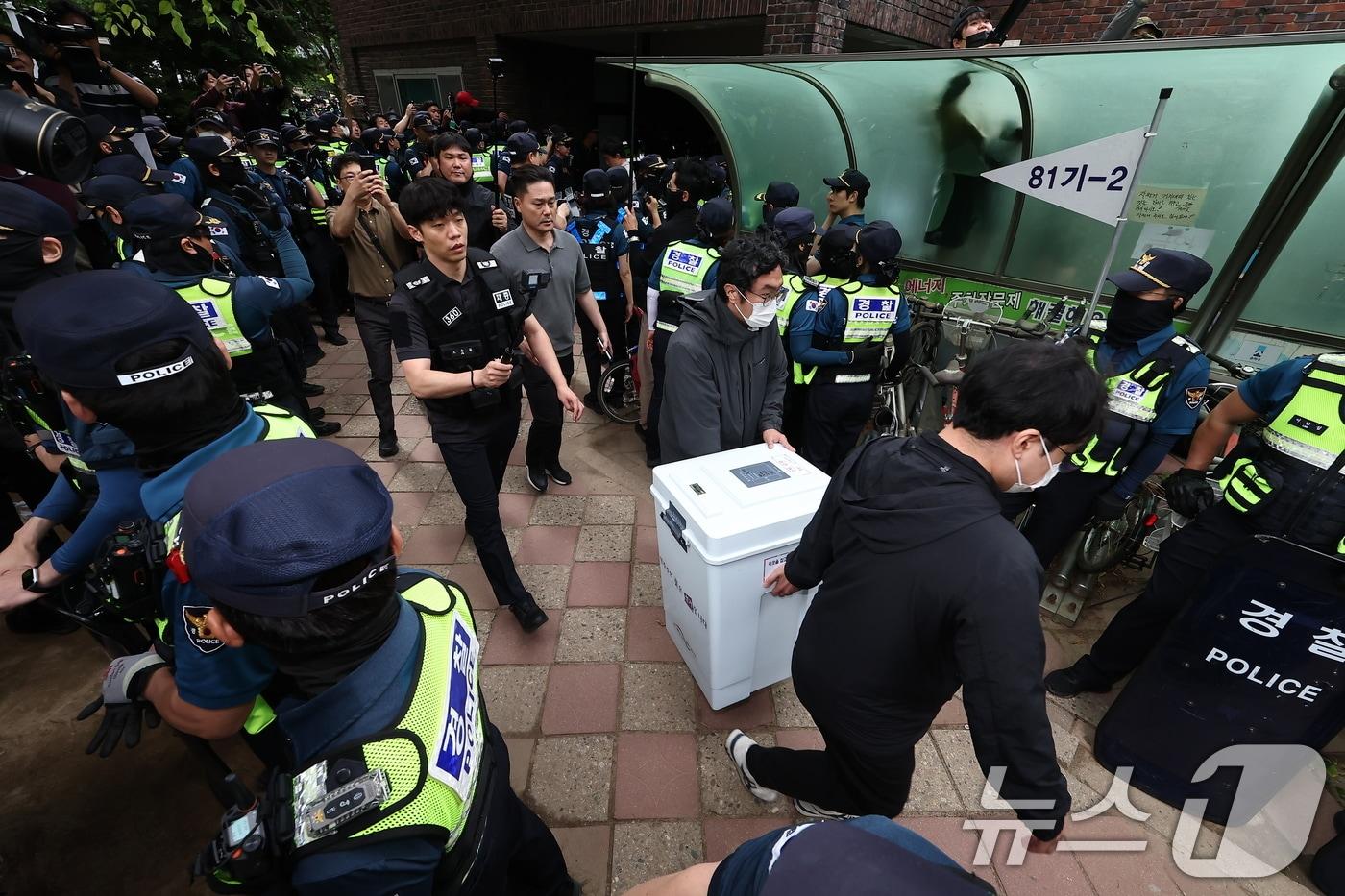 본문 이미지 - 5일 '투표용지 부족' 사태가 발생한 서울 송파구 잠실7동 제2투표소 앞에서 서울시선관위 관계자들이 투표함을 이송하고 있다. 2026.6.5 ⓒ 뉴스1 김도우 기자