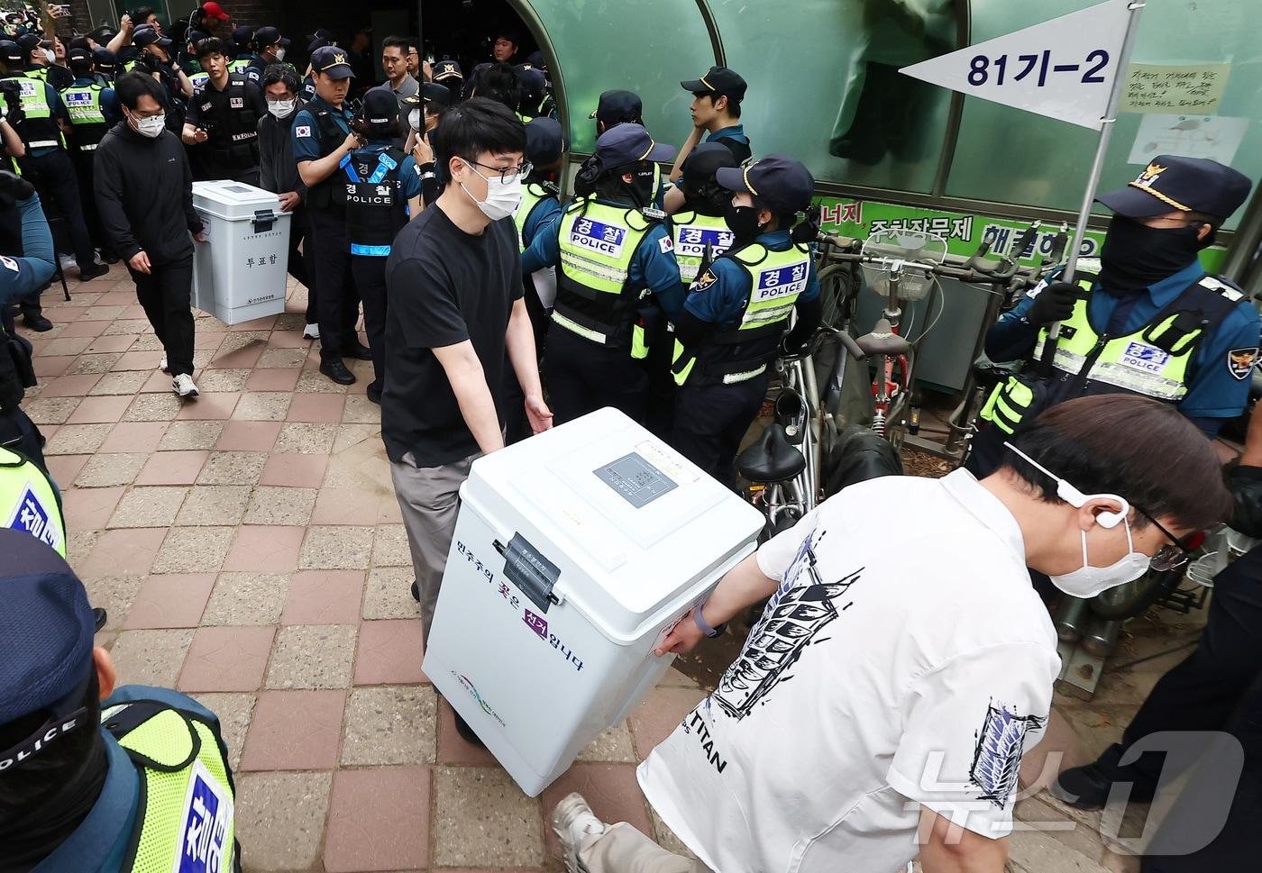 본문 이미지 - 5일 '투표용지 부족' 사태가 발생한 서울 송파구 잠실7동 제2투표소 앞에서 서울시선관위 관계자들이 투표함을 이송하고 있다. 2026.6.5 ⓒ 뉴스1 김도우 기자