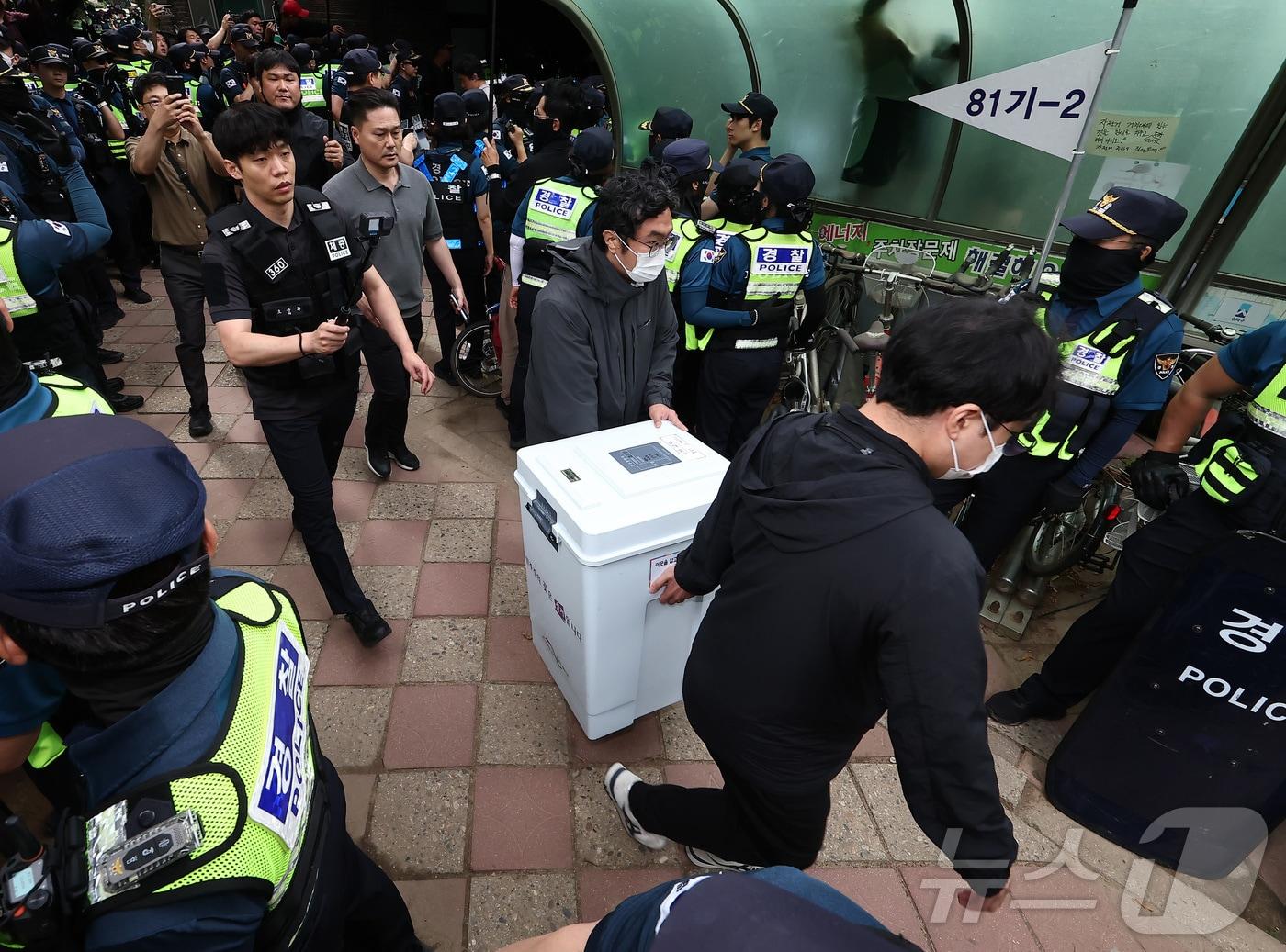 본문 이미지 - 5일 '투표용지 부족' 사태가 발생한 서울 송파구 잠실7동 제2투표소 앞에서 서울시선관위 관계자들이 투표함을 이송하고 있다. 2026.6.5 ⓒ 뉴스1 김도우 기자