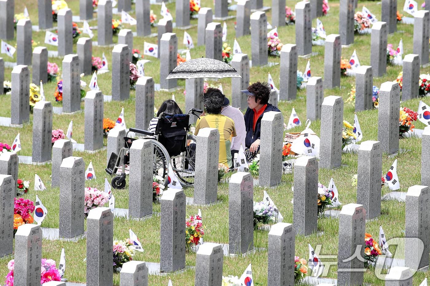 본문 이미지 - 현충일을 하루 앞둔 5일 경북 영천시 고경면 국립영천호국원을 찾은 시민들이 양산으로 뙤약볕을 가린 채 참배하고 있다. 2026.6.5 ⓒ 뉴스1 공정식 기자
