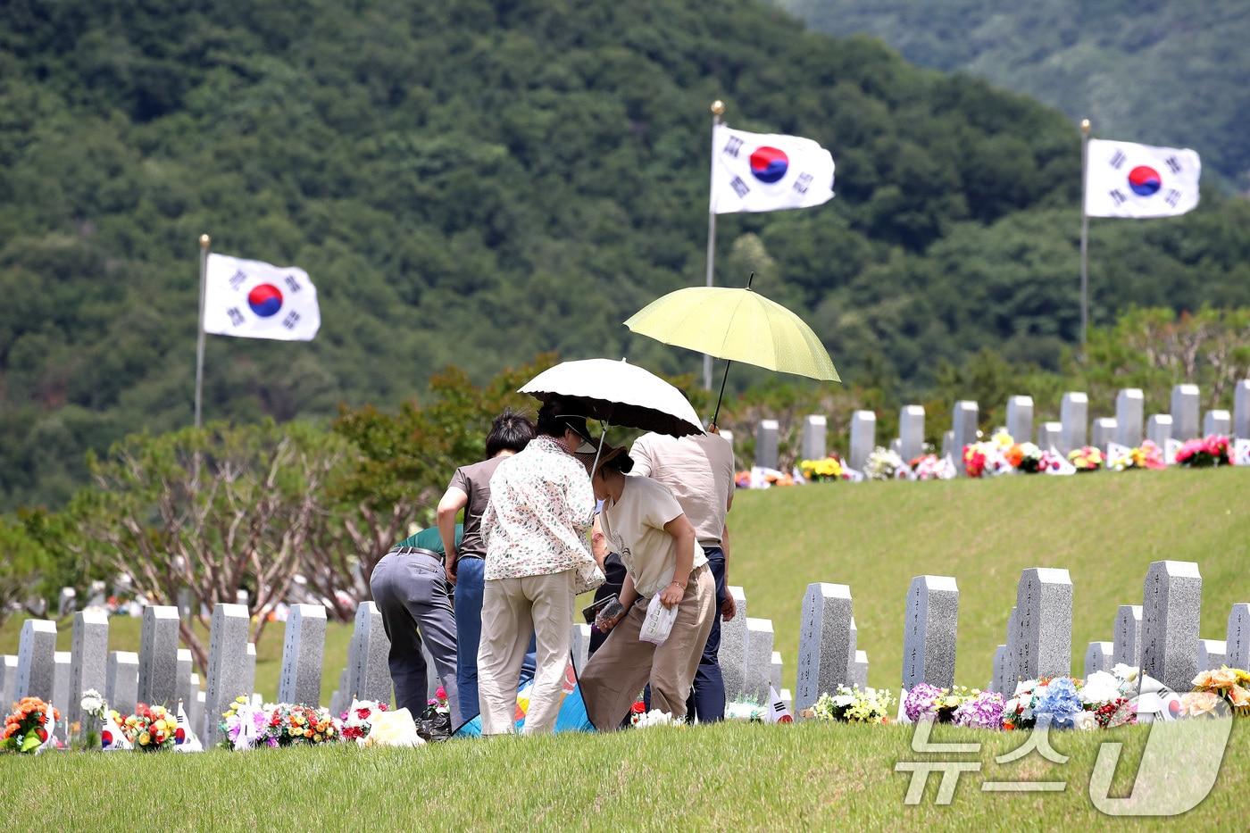 본문 이미지 - 영천 국립호국원을 찾은 시민들이 양산으로 뙤약볕을 가린 채 참배하고 있다. (사진은 기사 내용과 무관함) / 뉴스1 ⓒ News1