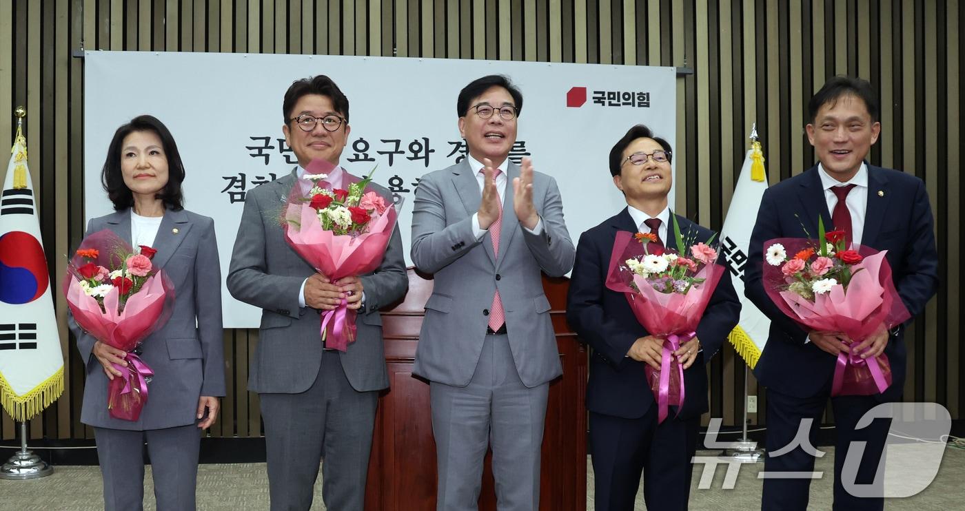 본문 이미지 - 6·3 재보궐선거로 당선된 국민의힘 이진숙, 유의동, 윤용근, 김태규 의원이 5일 오후 서울 여의도 국회에서 열린 의원총회에서 송언석 원내대표에게 꽃다발을 받고 기뻐하고 있다. 2026.6.5 ⓒ 뉴스1 황기선 기자