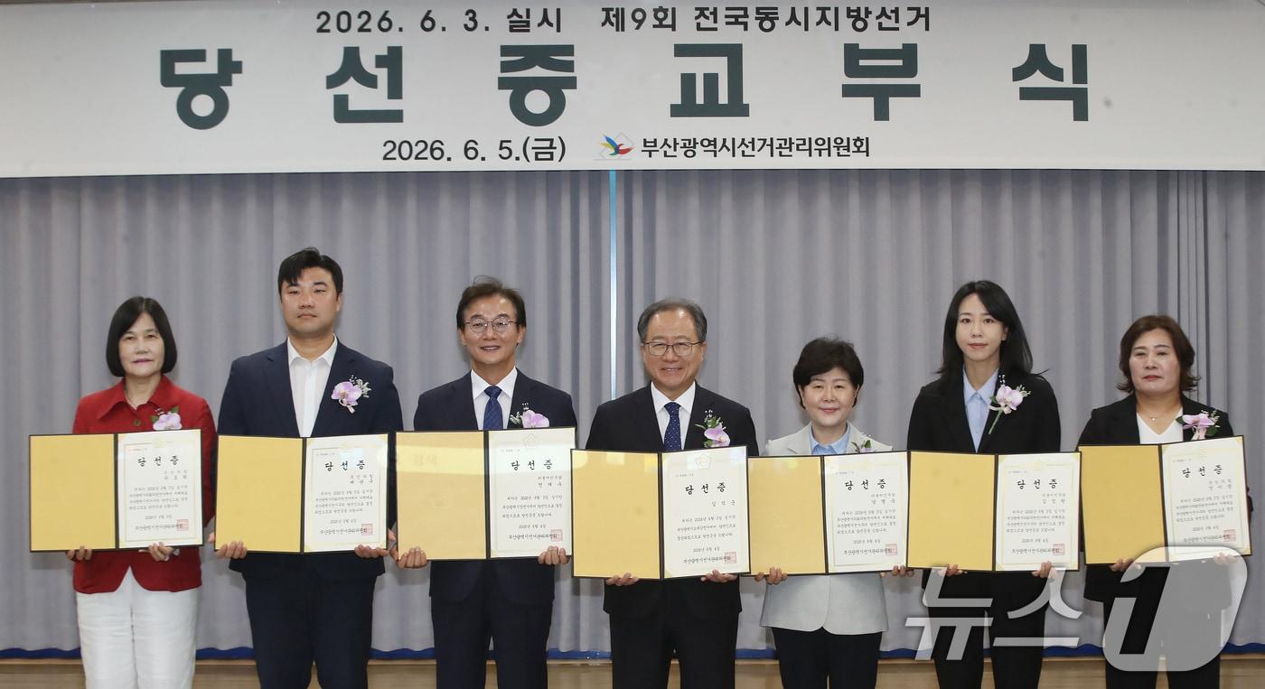 본문 이미지 - 전재수 부산시장 당선인, 김석준 부산시교육감 당선인, 비례대표부산광역시의회의원 당선인들이 오후 부산 연제구 부산시선거관리위원회에서 열린 제9회 전국동시지방선거 당선증 교부식에서 김문관 부산시선관위 위원장으로부터 당선증을 교부받은 뒤 기념촬영을 하고 있다. 2026.6.5 ⓒ 뉴스1 윤일지 기자