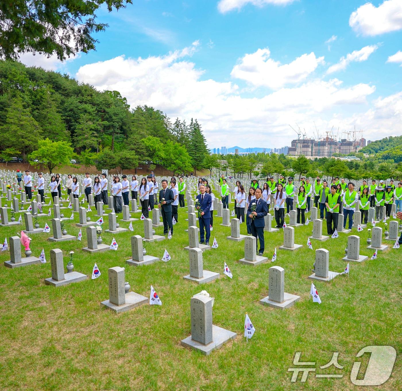 본문 이미지 - 권오을 국가보훈부 장관이 현충일을 앞둔 5일 오전 서울 동작구 국립서울현충원에서 농협 묘역 봉사자들과 헌화하고 있다. (국가보훈부 제공. 재판매 및 DB금지) 2026.6.5 ⓒ 뉴스1