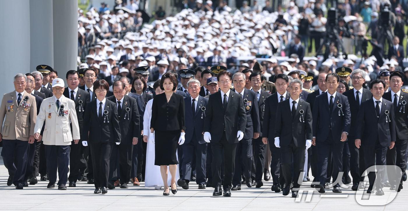 본문 이미지 - 이재명 대통령과 김혜경 여사가 6일 서울 동작구 국립서울현충원에서 열린 제71회 현충일 추념식에서 현충탑 참배를 위해 발걸음을 옮기고 있다. (청와대통신사진기자단) 2026.6.6 ⓒ 뉴스1 이재명 기자