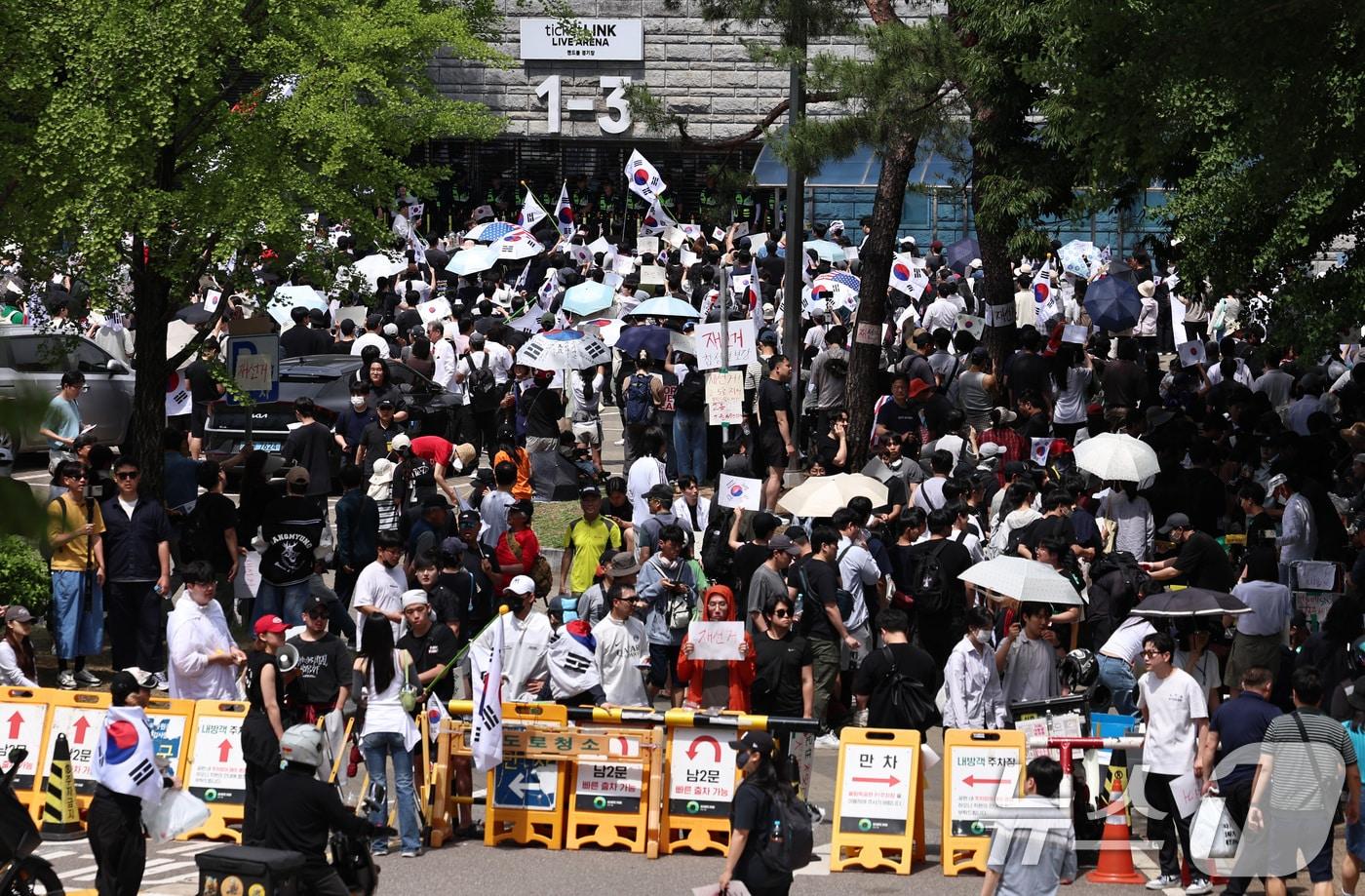 본문 이미지 - 6·3 지방선거 투표용지 부족 사태에 반발한 시민들이 6일 서울 송파구 올림픽공원 핸드볼경기장 개표소 앞에 모여 재선거를 요구하는 구호를 외치고 있다. 2026.6.6 ⓒ 뉴스1 구윤성 기자