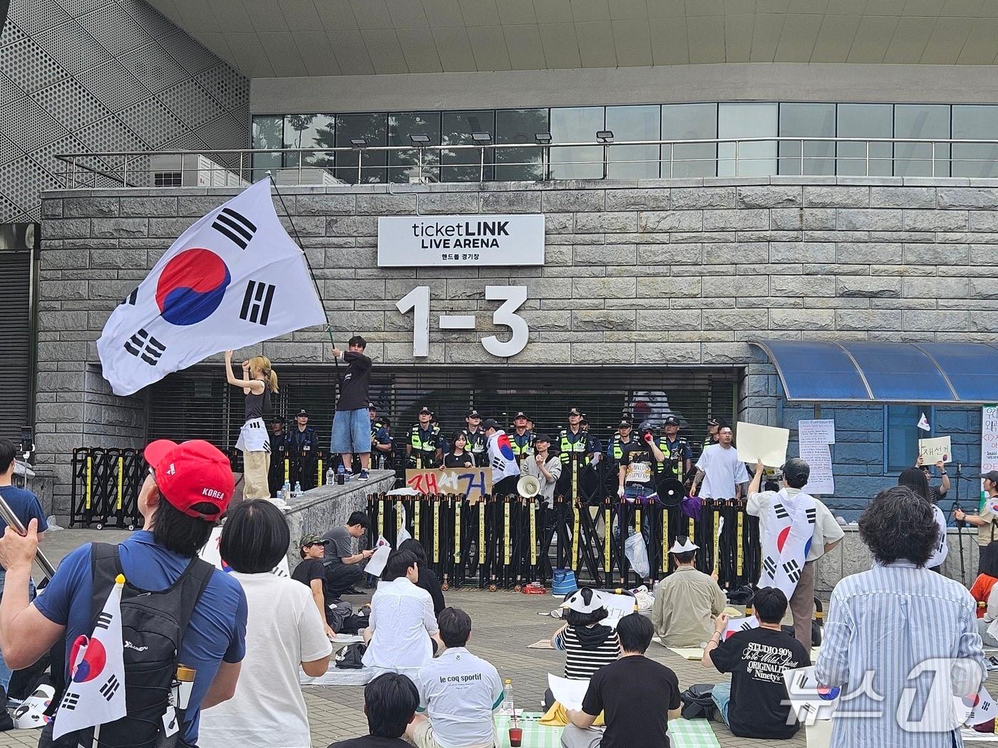 본문 이미지 - 6·3 지방선거 투표용지 부족 사태에 반발한 시민들이 7일 오 서울 송파구 올림픽공원 핸드볼경기장 개표소 앞에 모여 재선거를 요구하는 구호를 외치고 있다. 2026.6.7 ⓒ 뉴스1 유채연 기자