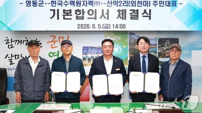 본문 이미지 - 정영철 영동군수(가운데)와 한국수력원자력 영동양수건설소장, 양강면 외천마 마을 주민대표들이 영동양수발전소 건설부지 추가 편입에 대한 기본합의서를 체결하고 있다. (영동군 제공. 재판매 및 DB금지)/뉴스1 