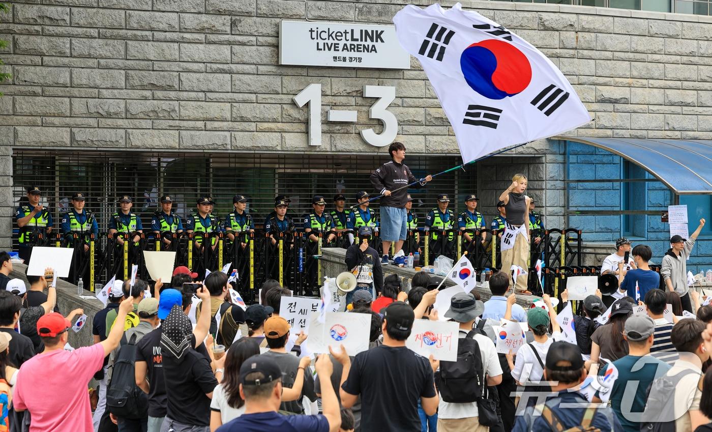 본문 이미지 - 제9회 전국동시지방선거 투표용지 부족 사태에 반발한 시민들이 7일 서울 송파구 올림픽공원 핸드볼경기장 개표소 앞에 모여 재선거를 요구하는 구호를 외치고 있다. 2026.6.7 ⓒ 뉴스1 이호윤 기자