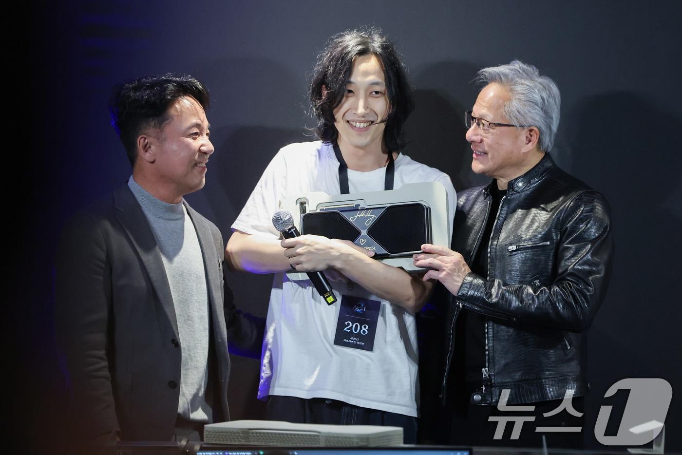 본문 이미지 - 젠슨 황 엔비디아 최고경영자(CEO)가 7일 오후 서울 서초구 포털 PC방에서 열린 엔씨소프트 다중접속 역할 수행 게임(MMORPG) '아이온2' 서프라이즈 라이브 행사에서 당첨자에게 최신 그래픽카드 '지포스RTX5090'을 선물하고 있다. 왼쪽은 김택진 엔씨소프트 대표이사. (공동취재) 2026.6.7 ⓒ 뉴스1 오대일 기자