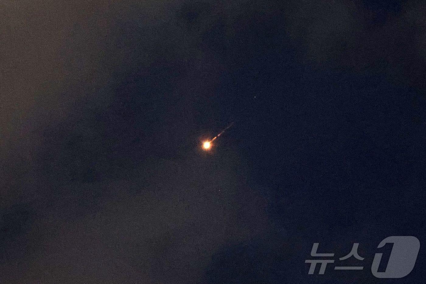 본문 이미지 - 7일(현지시간) 이스라엘 중부 해안도시 네타냐 상공에 이란이 발사한 미사일의 비행 궤적이 보이고 있다. 이스라엘군은 이날 새벽 이란이 발사한 미사일을 요격하기 위해 방공망을 가동했으며, 이는 지난 4월 휴전 이후 처음 발생한 이란의 직접 미사일 공격이다. 2026.6.7 ⓒ AFP=뉴스1