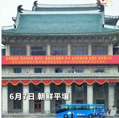 본문 이미지 - 7일 북한 평양 김일성광장 인민대학습당으로 보이는 건물 앞에 시진핑 중국 국가주석의 방문을 환영하는 현수막이 걸려있다. (신화통신 갈무리)