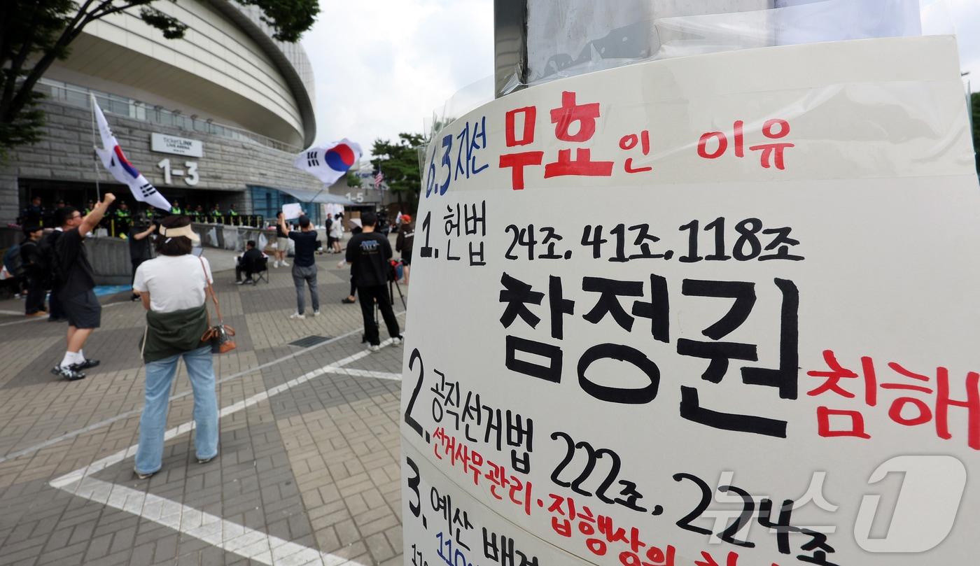 본문 이미지 - 제9회 전국동시지방선거 투표용지 부족 사태에 반발한 시민들이 8일 서울 송파구 올림픽공원 핸드볼경기장 개표소 앞에 모여 재선거를 요구하는 구호를 외치고 있다. 2026.6.8 ⓒ 뉴스1 김진환 기자