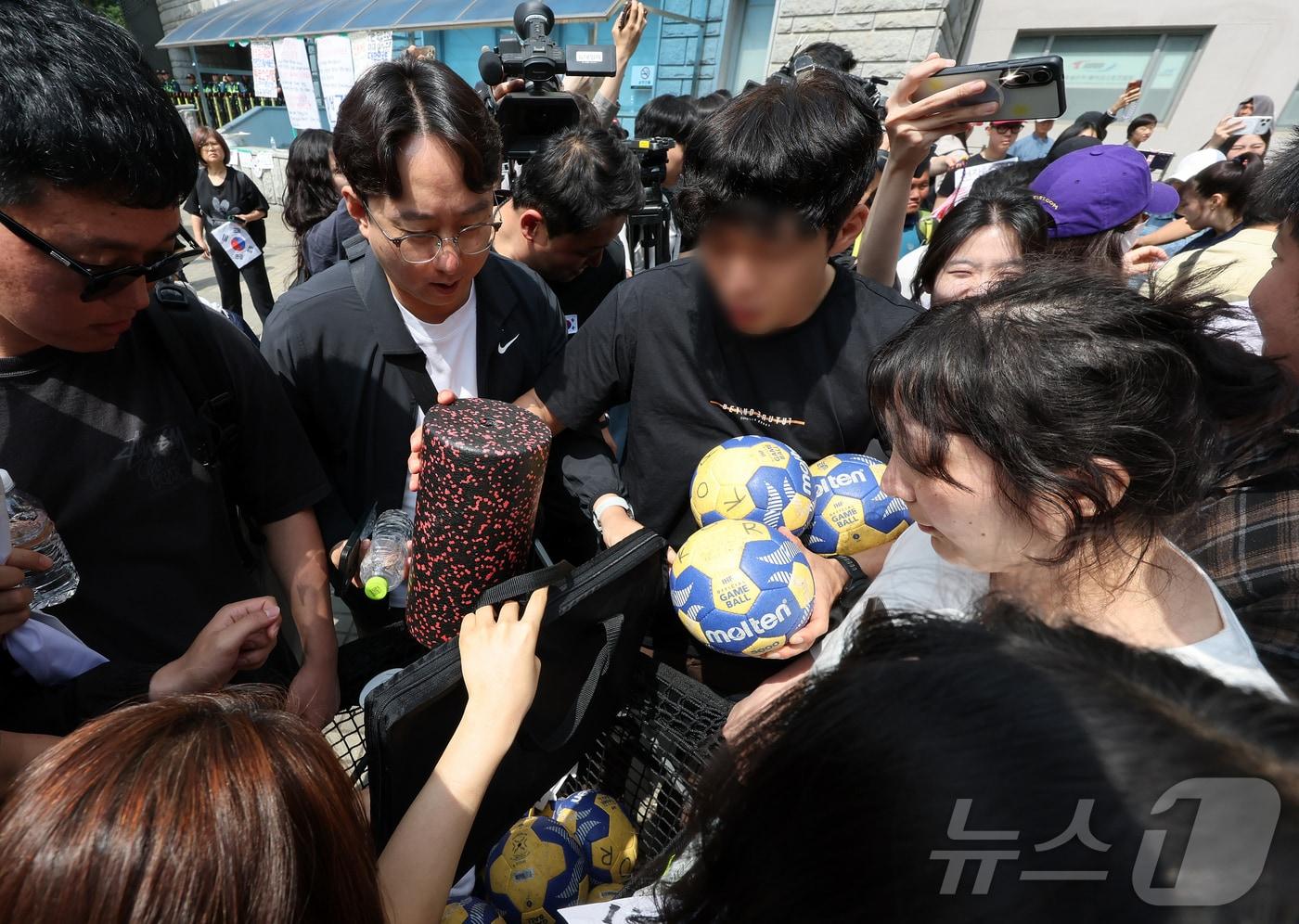 본문 이미지 - 제9회 전국동시지방선거 투표용지 부족 사태를 규탄하는 집회가 계속되고 있는 8일 재선거를 요구하는 시민들이 서울 송파구 올림픽공원 핸드볼경기장을 나온 핸드볼 주니어 대표팀 관계자의 물품을 확인하고 있다. 2026.6.8 ⓒ 뉴스1 김진환 기자