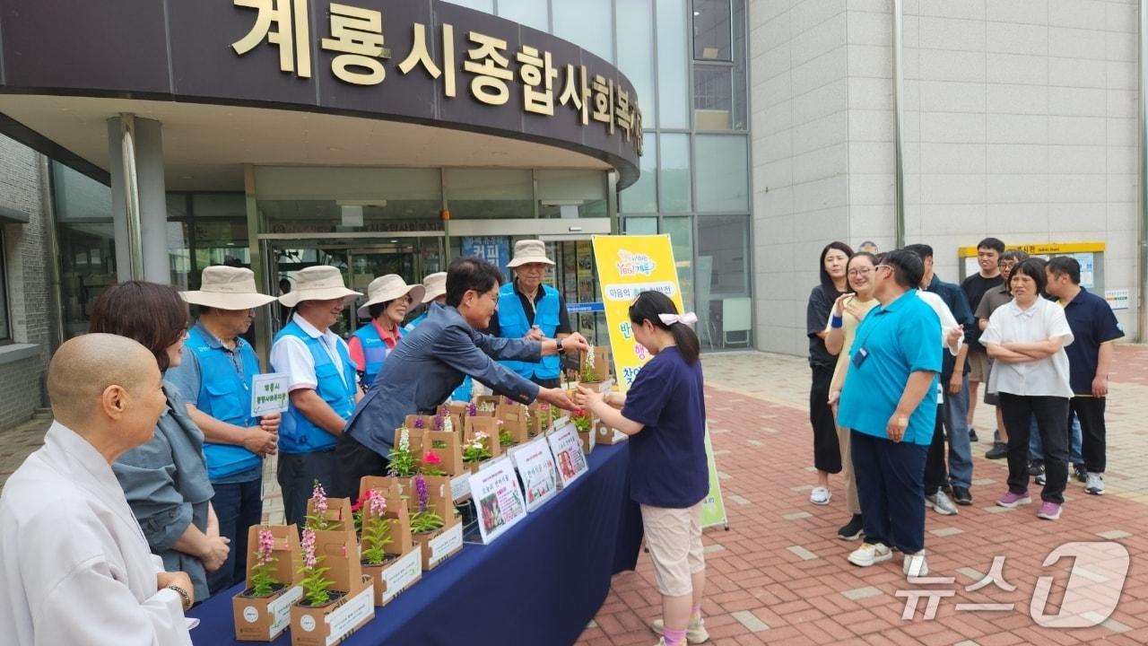 본문 이미지 - 계룡시는 8일 계룡시종합사회복지관에서 장애인 30명에게 반려식물을 전달하며 따뜻한 나눔 활동을 펼쳤다.(계룡시 제공.재판매 및 DB금지)/뉴스1