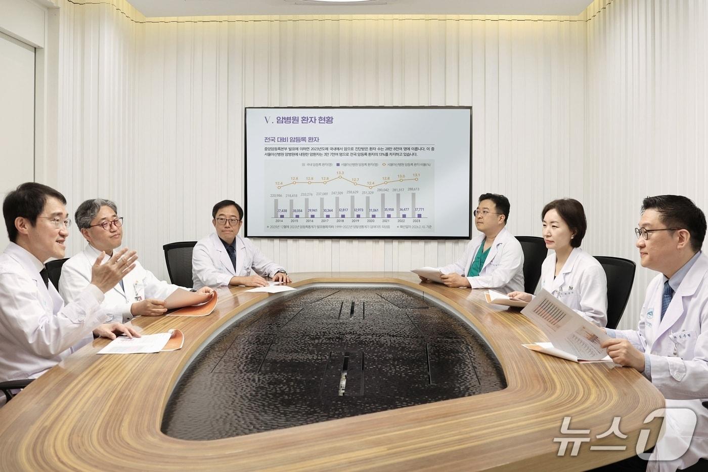 본문 이미지 - 송시열 서울아산병원 암병원장(사진 왼쪽)을 비롯한 병원 의료진이 센터별 암 치료 성과와 향후 운영 계획에 대해 논의하고 있다.(서울아산병원 제공)