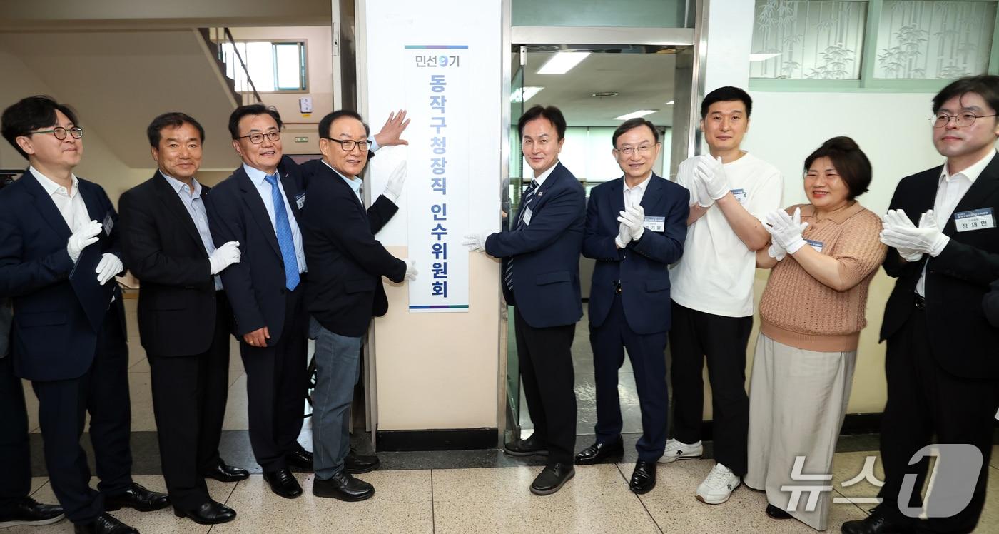 본문 이미지 - 류삼영 동작구청장 당선인(오른쪽 다섯번째)이 권대중 동작구청장직 인수위원장(왼쪽에서 네번째) 및 인수위원들과 8일 동작구 노량진 舊청사에서 열린 민선9기 동작구청장직 인수위원회 출범식 현판을 걸고 있다.(동작구청 제공)