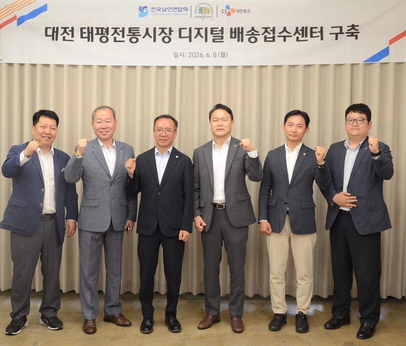 본문 이미지 - 지난 8일 열린 '대전 태평시장 배송접수센터 개소식'에서 윤재승 CJ대한통운 오네(O-NE)본부장(왼쪽 네 번째), 이충환 전국상인연합회 회장(왼쪽 세 번째) 등 참석자들이 기념촬영을 하고 있다.(CJ대한통운 제공)