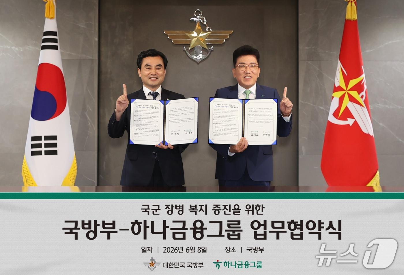 본문 이미지 - 하나금융그룹은 지난 8일 오후 서울 용산구 소재 국방부 청사에서 국방부와 업무협약을 체결하고, 대한민국 군 장병들의 사기 증진 및 복지 향상을 위한 「히어로 위드 하나(Hero with Hana)」 프로그램을 실시한다고 밝혔다. 이날 협약식에 참석한 함영주 하나금융그룹 회장(사진 오른쪽)과 안규백 국방부 장관(사진 왼쪽)이 기념촬영을 하고 있다.2026.06.08 / 사진제공=하나금융그룹