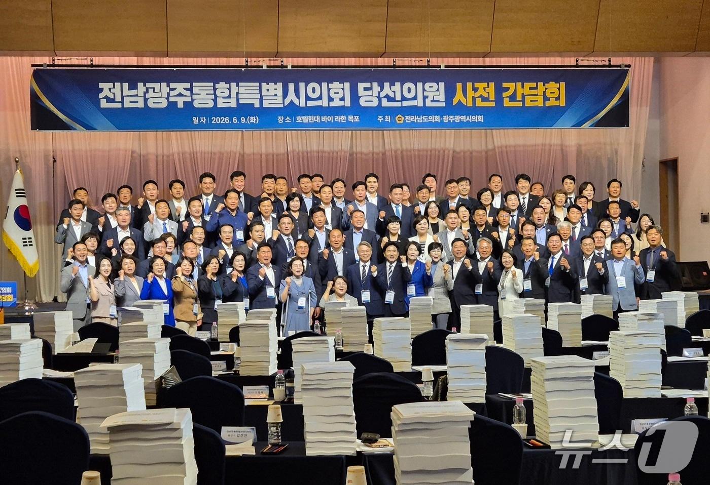 본문 이미지 - 전남광주통합특별시의회 당선인들이 간담회에 앞서 기념사진을 찍고 있다. 당선의원들의 책상에 '통합시의회 사전 보고'자료가 높이 쌓여 있다. 2026.6.9. 뉴스1 ⓒ News1 조영석 기자 