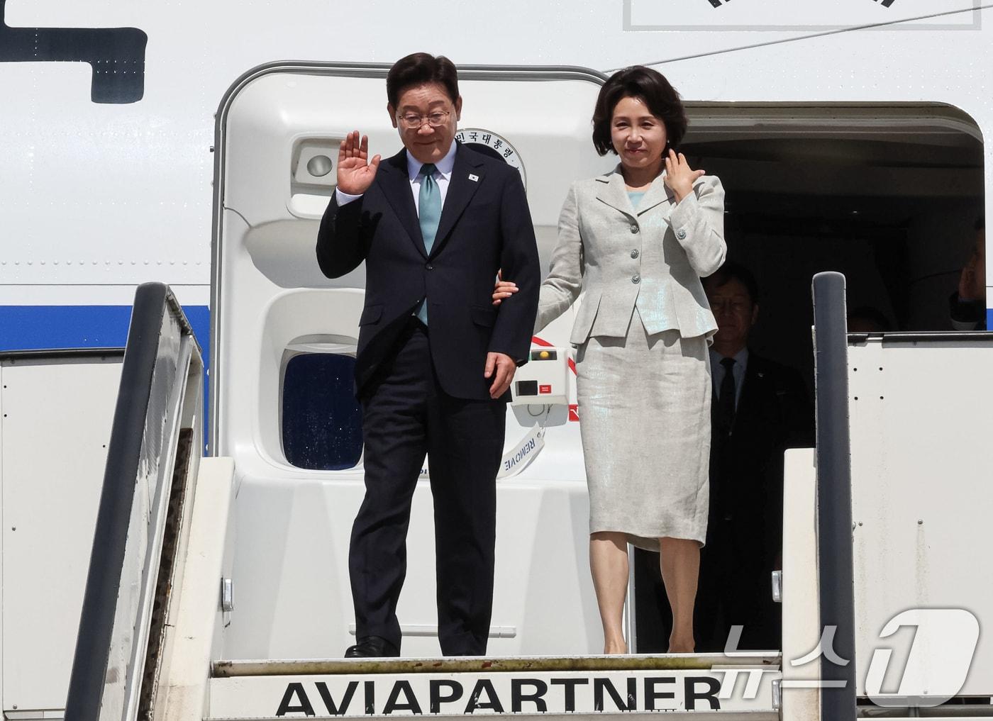 본문 이미지 - G7 정상회의 참석차 유럽 순방 일정에 나선 이재명 대통령과 김혜경 여사가 9일(현지시간) 벨기에 멜스브루크 군공항에 도착해 환영객들에게 인사하고 있다. 2026.6.9 ⓒ 뉴스1 허경 기자